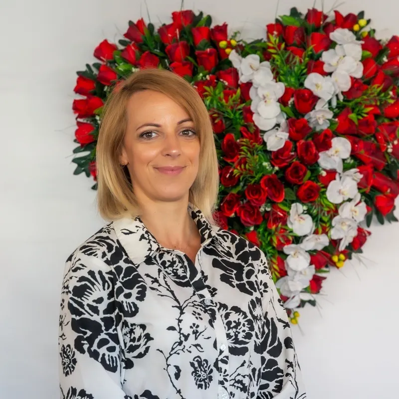 Vanessa Larose, maître de cérémonie funéraire, devant un cœur de fleurs de deuil