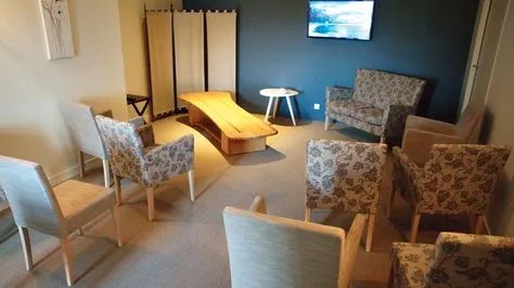 Salon funéraire de recueillement aménagé avec fauteuils et table basse pour les familles