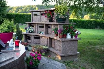 Columbarium en granit fleuri dans un cimetière paysager pour le dépôt d'urnes funéraires